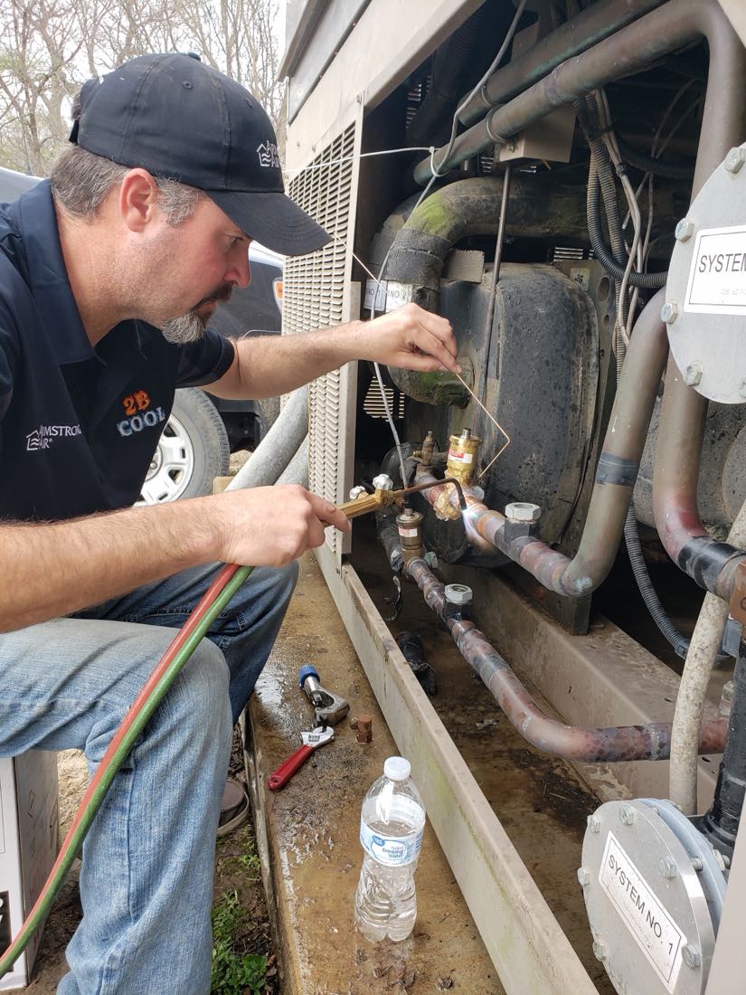 2B Cool HVAC technician brazing copper lines on a commercial cooling system